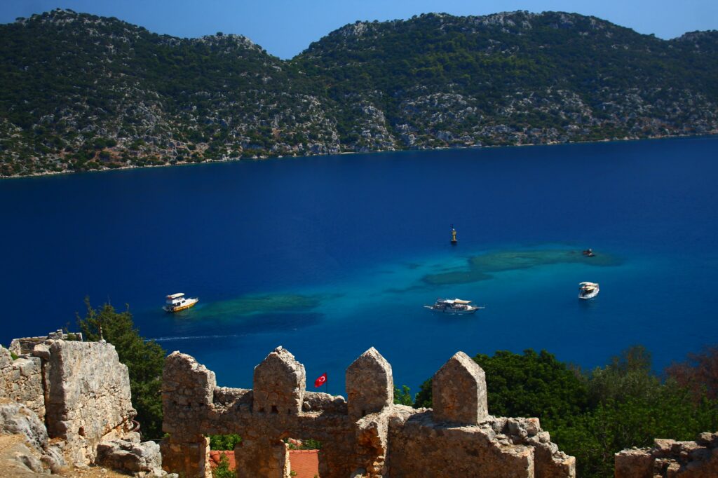 Ruins above the water at Kekova, with boats over the sunken city