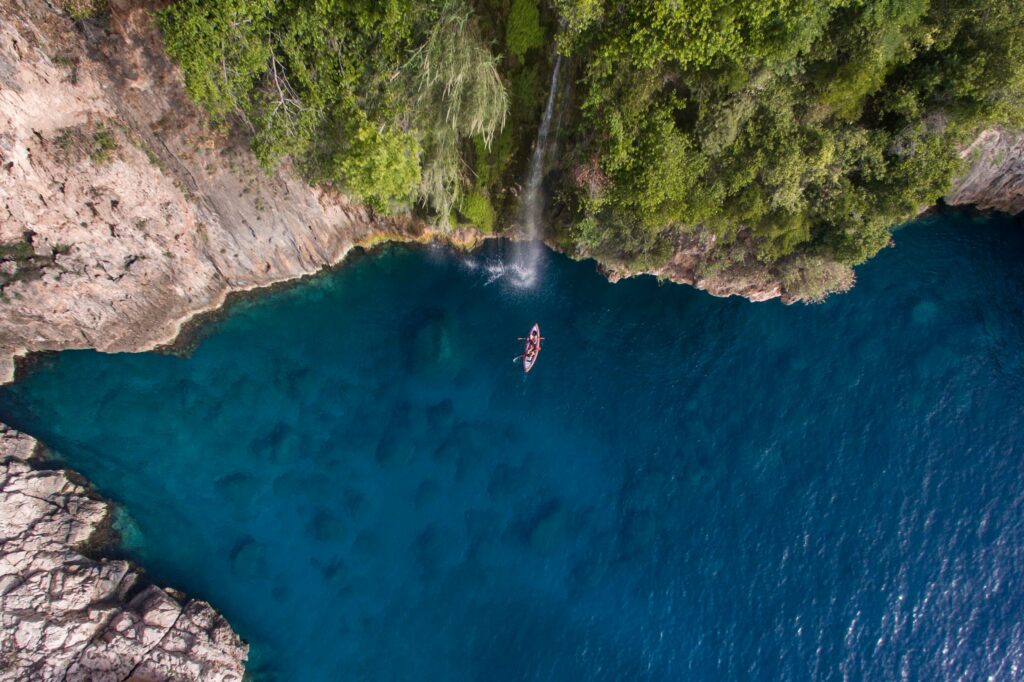 A kayak below the waterfall in a cove near Kaş