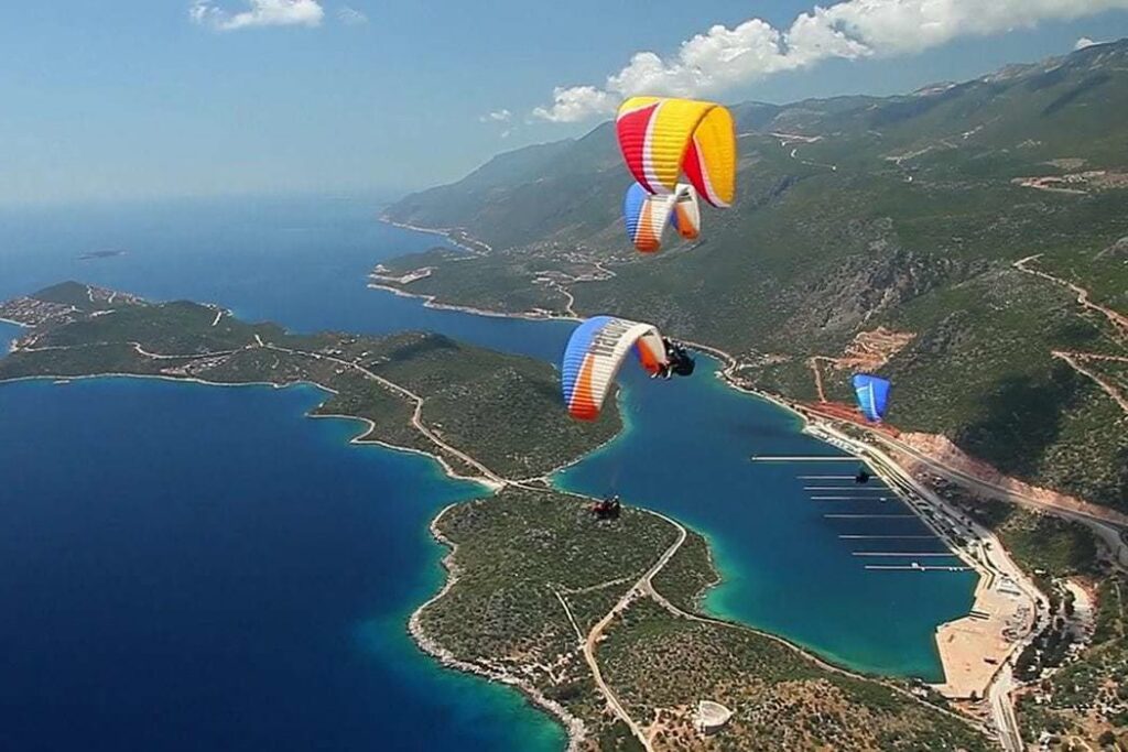 Paragliders above the Çukurbağ peninsula and the marina at Kaş
